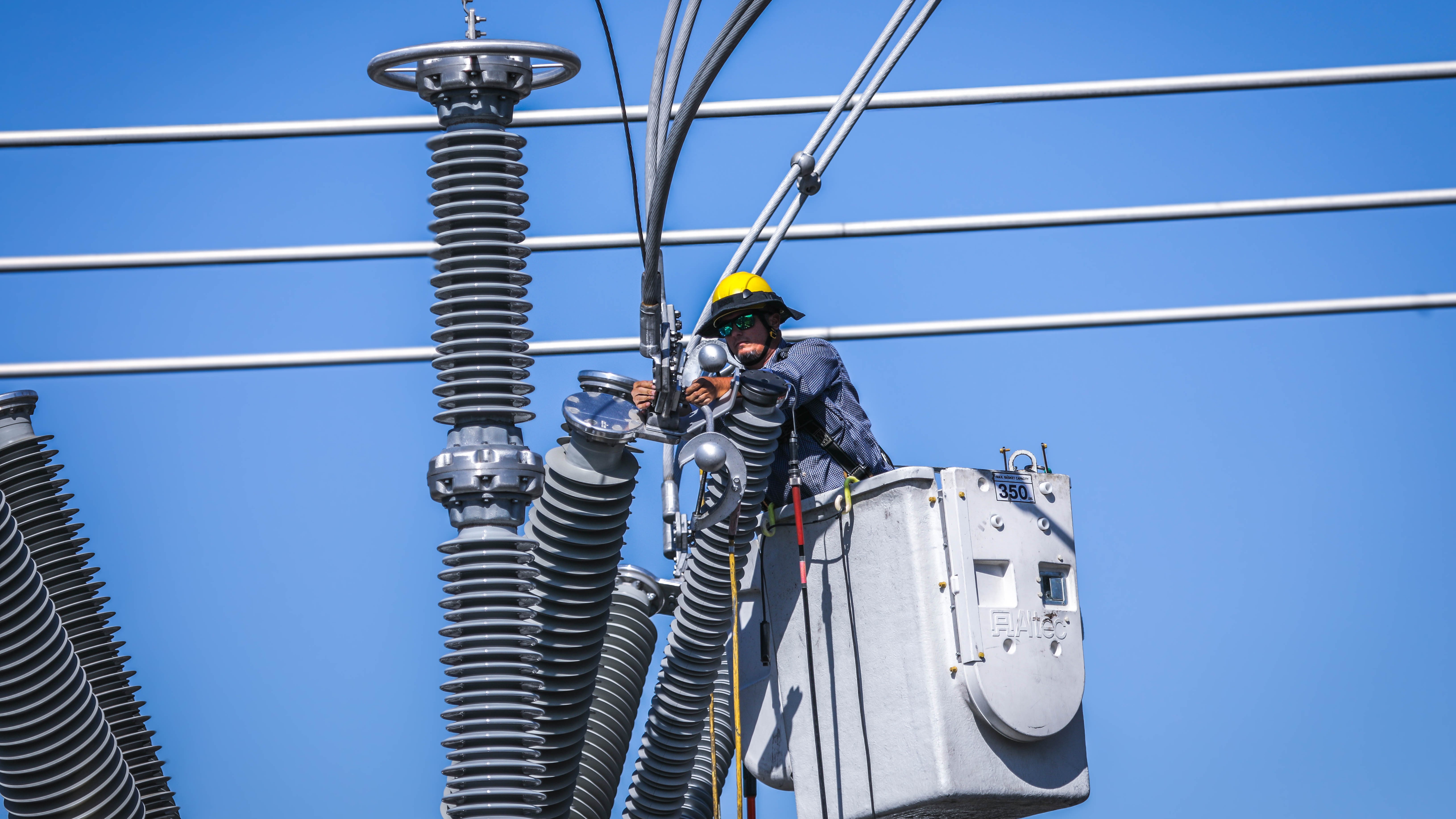 man in elevated bucket working on electrical equipment