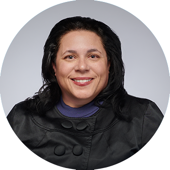 picture of woman with long dark hair, wearing a dark shirt, set against a grey background, photo in shape of circle